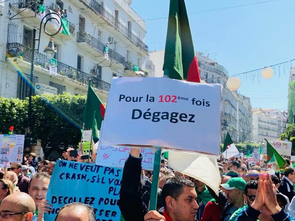 "Pela centésima segunda vez: Fora!". Cartaz faz alusão ao artigo 102 da Constituição argelina. Foto de Nesrine Kheddache