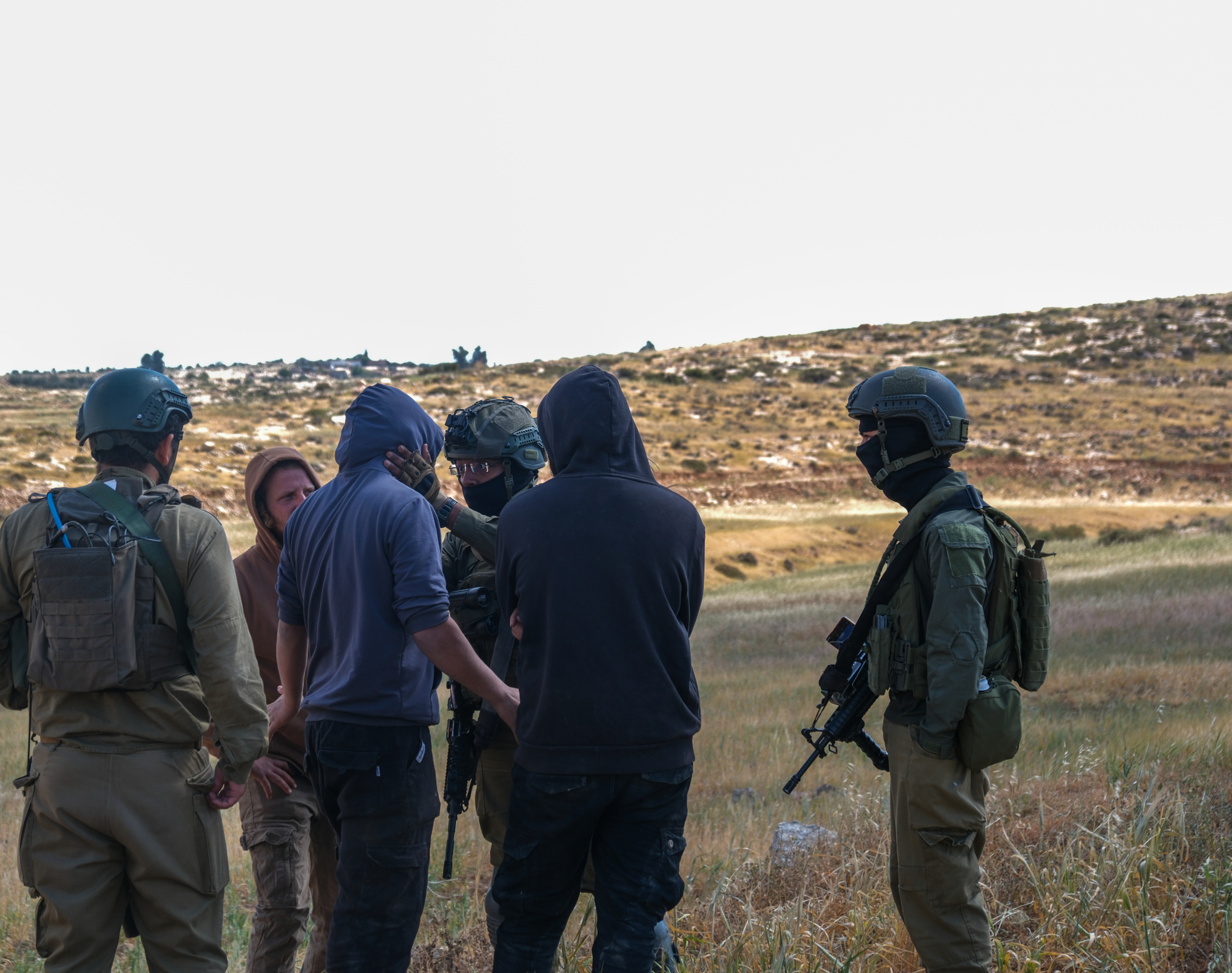 Um soldado israelita fala com um colono em Wadi Al-Rakhim, na Cisjordânia, a 25 de abril de 2025. (Georgia Gee)
