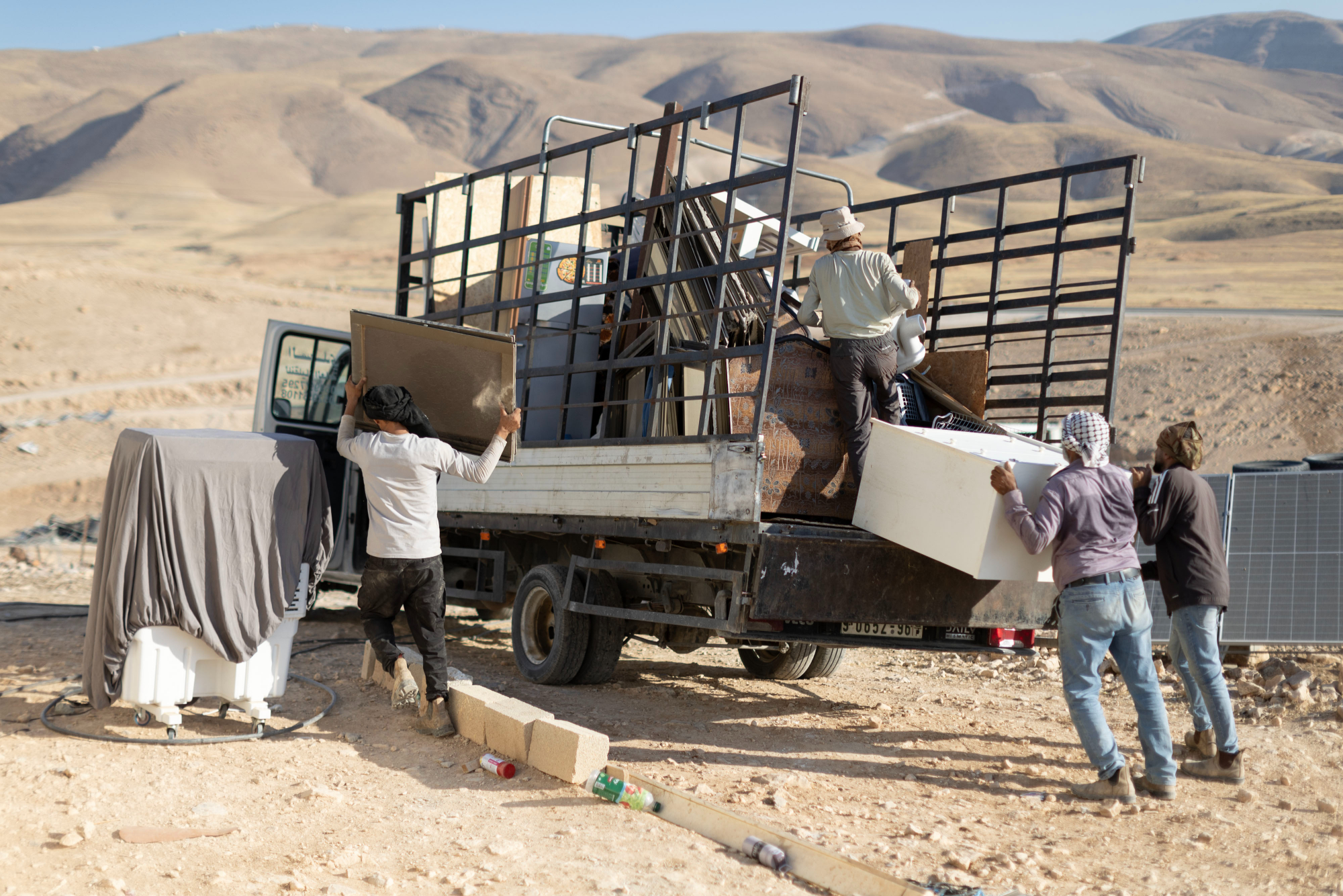 Palestinianos carregam camiões com os seus pertences enquanto evacuam a aldeia de Al-Muarrajat, na Cisjordânia, a 4 de julho de 2025. (Avishai Mohar/ Activestills)