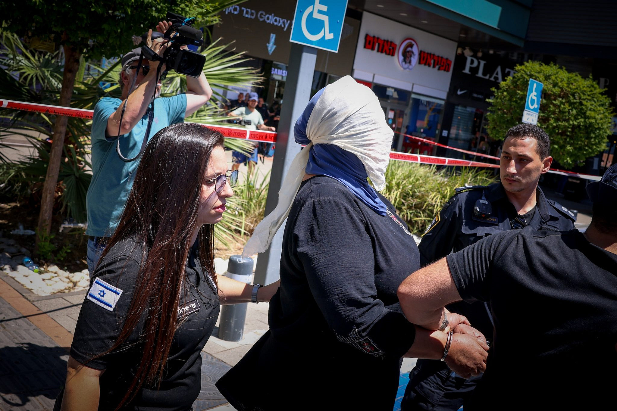 A polícia israelita prende uma mulher palestiniana em Karmiel, norte de Israel, em 3 de julho de 2024.