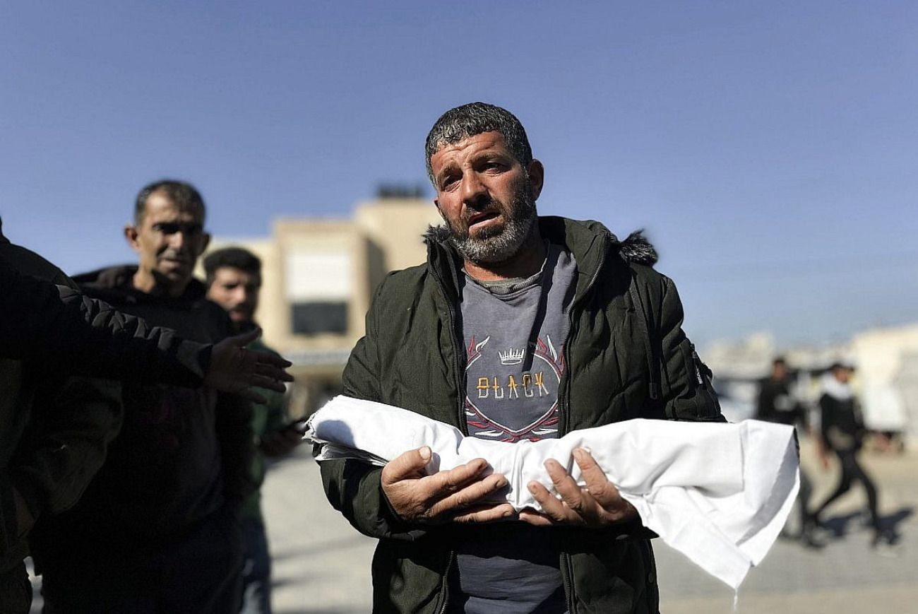 Assad Abdeen carrega o corpo do seu filho de um mês, Saeed, que morreu devido à exposição ao frio, no Hospital Al-Nasser, em Khan Younis, em 18 de dezembro de 2025