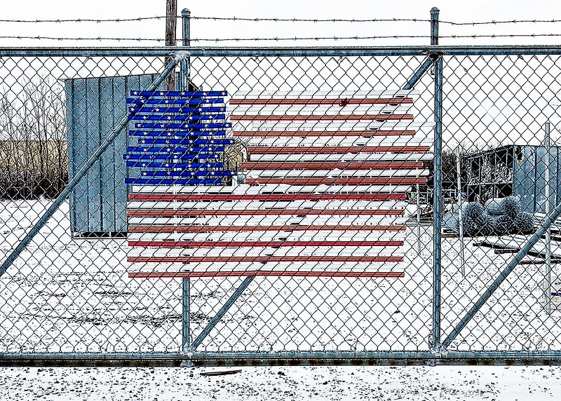 Bandeira americana numa vedação de arame farpado. Foto de Glen Zazove/Flickr.