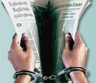 Mãos acorrentadas tentam abrir páginas de jornal