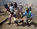 Pai foge com os filhos, perante a violência instalada. Foto da France Press