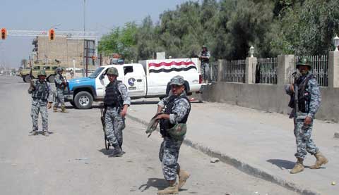 Polícias iraquianos fazem uma barreira de rua em Bassorá. Foto EPA/HAIDER AL-ASSADEE