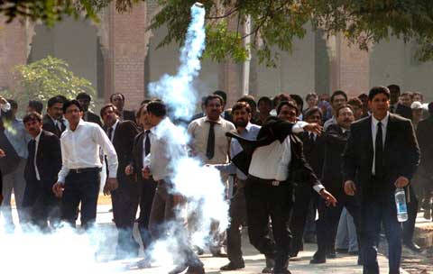 Advogado devolve bomba de gás lacrimogénio em Lahore. Foto EPA/Lusa 