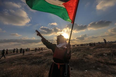 Mulher idosa protesta com bandeira da Palestina erguida, Gaza, 21 de agosto de 2021 – Foto de Mohammed Saber/Epa/Lusa 