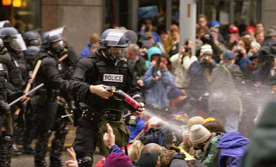 Polícia dispara gás lacrimogéneo sobre manifestantes sentados. Seattle, 30 de novembro de 1999.