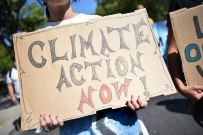 Cartaz onde se lê "Climate action now