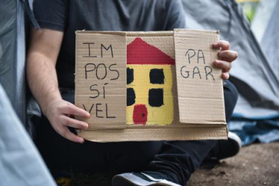 Cartaz com uma casa desenhada no meio e as palavras "Impossível" e "pagar" a ladeá-la.
