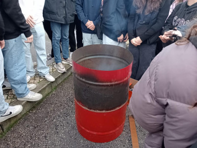 Alunos aquecem-se junto a bidão.