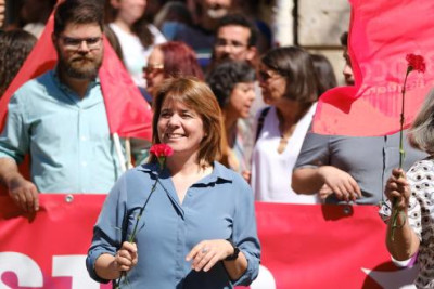 Catarina Martins numa manifestação com um cravo vermelho na mão.