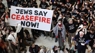 Protesto com cartaz onde se lê: "Jews say ceasefire now