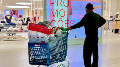 homem com carrinho de supermercado num centro comercial