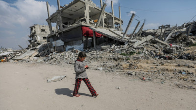 Menina passeia junto a edifícios destruídos no campo de refugiados de Jabalya, no norte da Faixa de Gaza