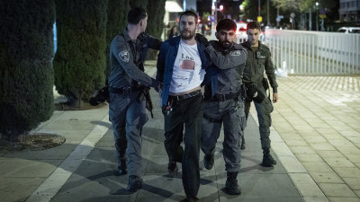 Agentes da polícia detêm um manifestante numa manifestação contra a guerra de Israel com o Irão, na Praça Habima, em Telavive, a 28 de março de 2026.
