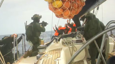 Comando israelita aponta arma aos voluntários da flotilha humanitária durante o assalto ilegal