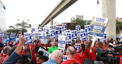 Trabalhadores com cartazes da UAW sobre a greve no setor dos automóveis. Foto do sindicato.