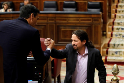 Pedro Sánchez e Pablo Iglesias cumprimentam-se durante o debate de investidura do governo espanhol. Janeiro de 2020.