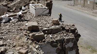 No dia em que passavam cinco anos do início da guerra no Iémen, um homem passeia junto a destroços em Sanaa. Foto de YAHYA ARHAB/EPA/LUSA.