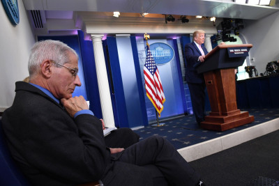 Anthony Fauci ouve Trump durante a conferência de imprensa sobre a evolução da pandemia, abril de 2020. Foto de KEVIN DIETSCH/EPA/LUSA.
