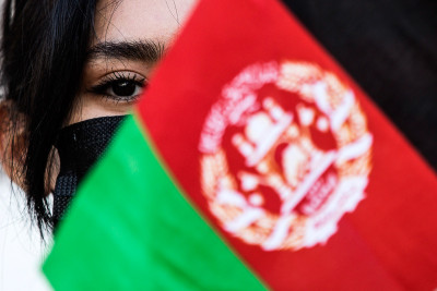 mulher por detrás de bandeira do Afeganistão