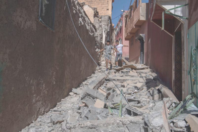 Crianças caminham sobe os escombros de edifícios destruídos pelo sismo em Marraquexe.