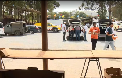Imigrantes indianos retiram comida de um carro para distribuir.
