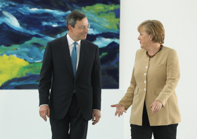 Na zona euro, este aparente paradoxo da política monetária é a expressão de problemas mais profundos - Foto Mario Draghi e Angela Merkel