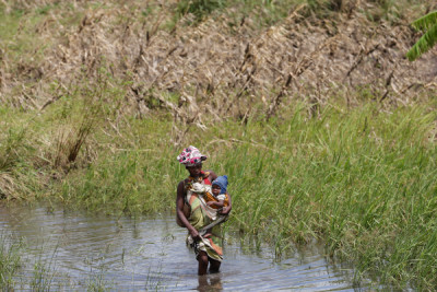 Mulher com criança na única via de acesso possível na zona de João Segredo onde a estrada nacional 6 foi interrompida pelo ciclone Idai na província de Sofala, centro de Moçambique, 23 de março de 2019. Foto de Tiago Petinga/Lusa