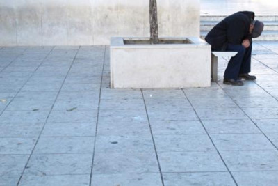 Pessoa isolada com a cabeça encostada nas suas próprias pernas.