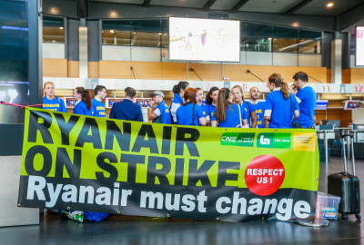 “Ryanair em greve – Respeitem-nos! Ryanair deve mudar”, faixa empunhada por trabalhadores e trabalhadoras da Ryanair no aeroporto de Charleroi, na Bélgica, em 25 de julho de 2018 – Foto de Stephanie Lecocq/Epa/Lusa