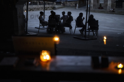 Ourense, Galiza. Pessoas convivem num bar à luz de velas.