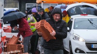 Pessoas transportam telhas na Marinha Grande
