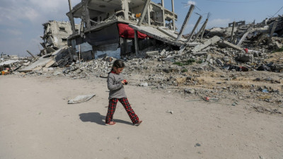 Menina passeia junto a edifícios destruídos no campo de refugiados de Jabalya, no norte da Faixa de Gaza
