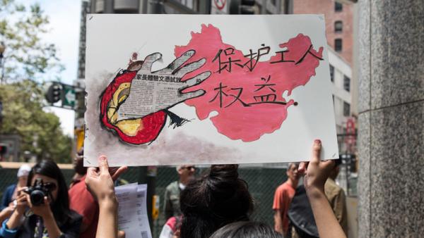 Cartaz "Proteção dos direitos dos trabalhadores" num protesto à porta da Apple em São Francisco contra o desrespeito laboral por parte das multinacionais que operam na China.