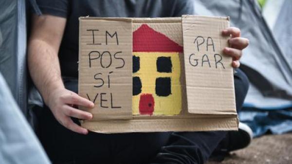 Cartaz com uma casa desenhada no meio e as palavras "Impossível" e "pagar" a ladeá-la.