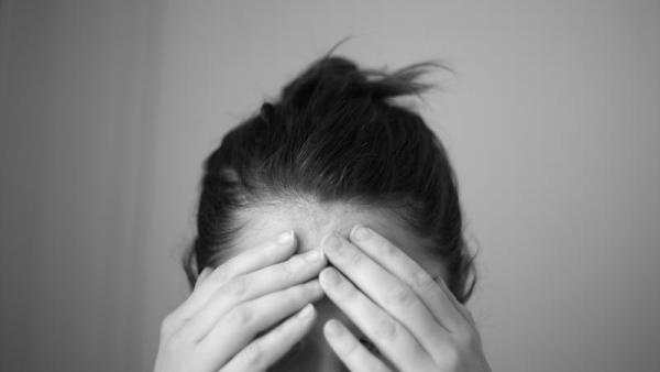 Pessoa com as mãos a tapar a face.