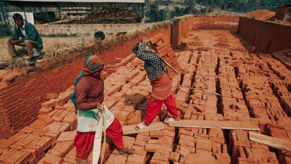 Mulheres a carregar tijolos.