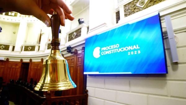 mão com sineta na sala do Conselho Constitucional