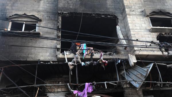 Roupas de uma família palestiniana nos destroços de um edifício no campo de refugiados de Nuisarat. Foto de MOHAMMED SABER/EPA/Lusa.