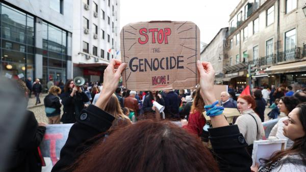 Manifestação contra massacre na Palestina. Cartaz onde se lê "Stop the genocide now!
