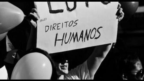 Manifestante com cartaz sobre luta pelos direitos humanos.