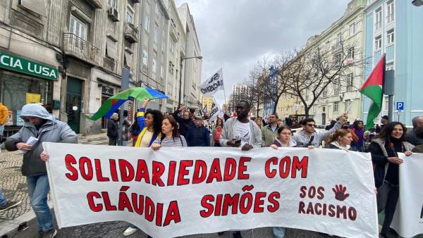 manifestantes com faixa em solidariedade com Cláudia Simões