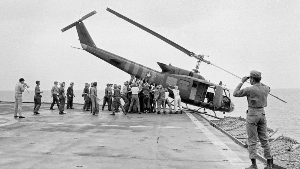 O sargento James W. Washington do U.S. Marine Corps tirando uma fotografia de um helicóptero Iroquois empurrado borda fora do “USS Blue Ridge” durante a operação de evacuação.