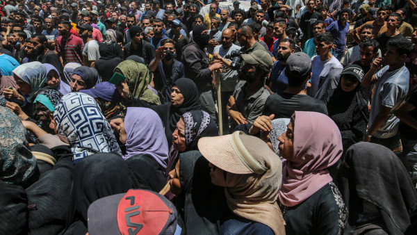 Refugiados palestinianos à espera de auxílio humanitário. Foto de MOHAMMED SABER/EPA/Lusa.