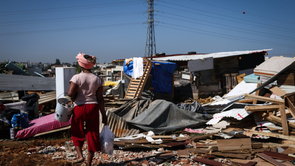 Uma moradora passa por destroços das habitações demolidas no Bairro do Talude Militar em Loures.