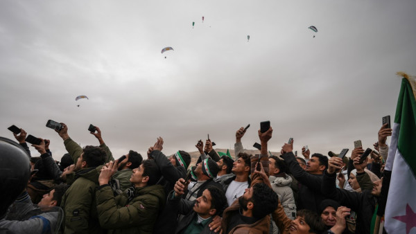 Pessoas assistem à marcha dos soldados do exército sírio durante um desfile que marca o primeiro aniversário da derrubada do regime de Bashar Al-Assad em Damasco, Síria, em 8 de dezembro de 2025.