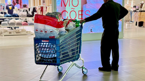 homem com carrinho de supermercado num centro comercial
