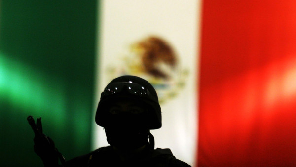 silueta de soldado com bandeira do México em fundo
